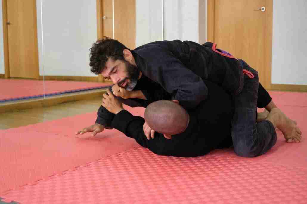Two men practicing Brazilian Jiu-Jitsu wrestling at the Academy.